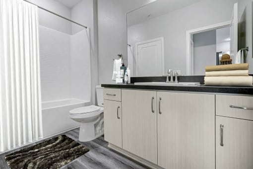 a bathroom with white cabinets and a toilet and a shower