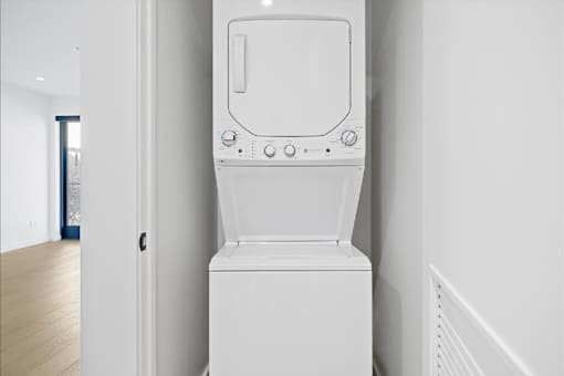 A white washing machine in a room with white walls.