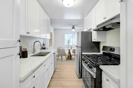 A kitchen with white cabinets and a black stove top oven.