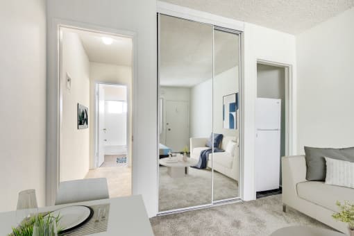 a living room with mirrors and a couch and a table