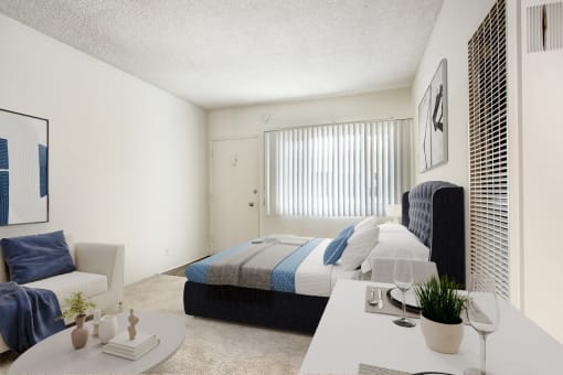 a bedroom with a bed and a white table and a couch