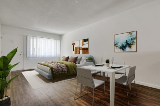 an open living room and dining room with a bed and a table and chairs