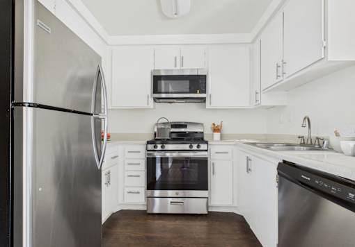 A modern kitchen with stainless steel appliances and white cabinets.