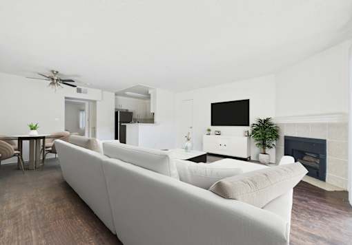 A living room with a white couch and a fireplace.