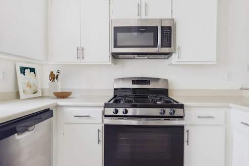 A modern kitchen with a stove, oven, and microwave.