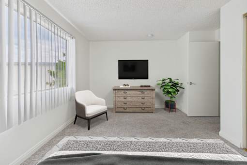 A room with a chair, a cabinet, and a television.