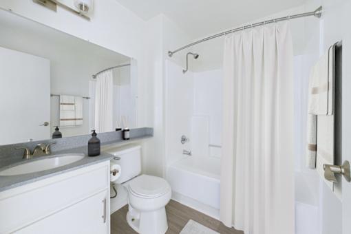 A white bathroom with a toilet, sink, and bathtub.
