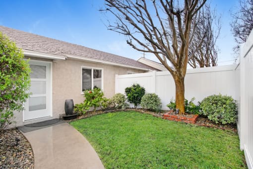 a house with a yard and a tree in front of it