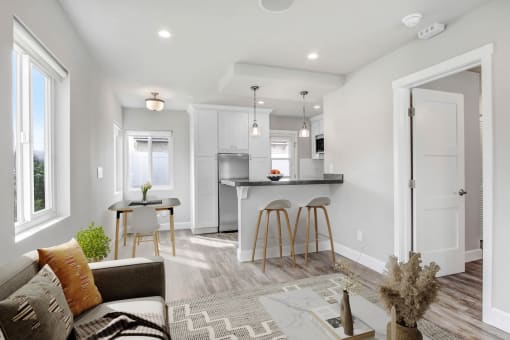 a living room with a kitchen with a bar and a couch
