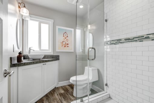 a white bathroom with a shower toilet and sink