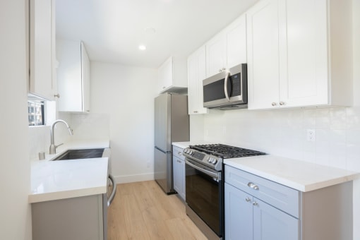 a kitchen with white cabinets and a stainless steel stove