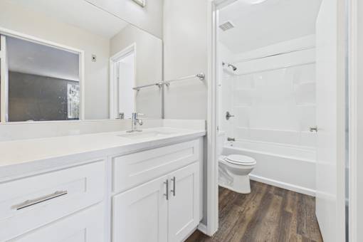 A white bathroom with a toilet, sink, and bathtub.