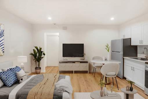 A modern bedroom with a bed, a chair, a table, and a television.