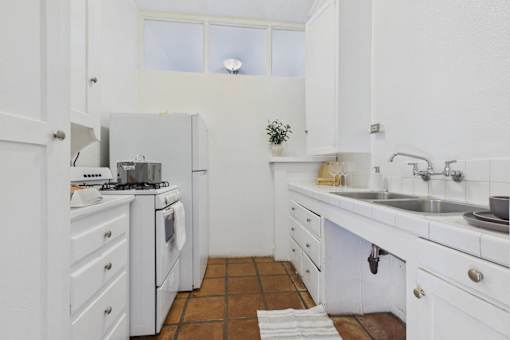 A small white kitchen with a tiled floor.