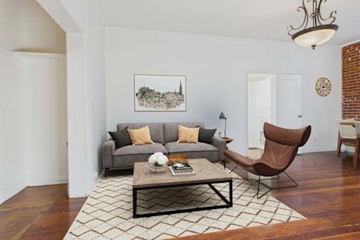 A living room with a grey couch, a brown chair, and a coffee table.