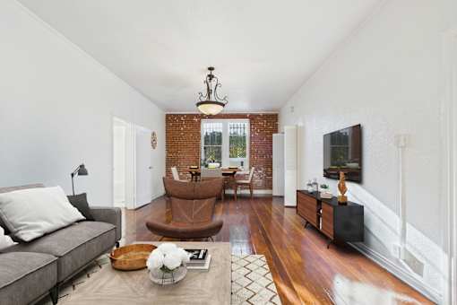 A living room with a grey couch and a brown chair.