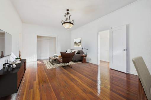 A living room with a brown chair and a wooden floor.