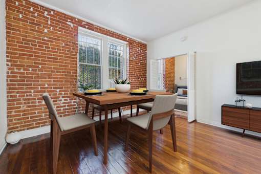 A dining room with a wooden table and chairs.