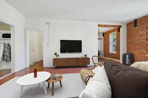A living room with a white couch and a wooden coffee table.