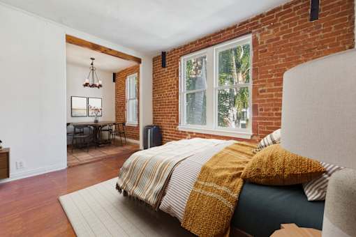 A bedroom with a bed covered in a yellow and white striped comforter.