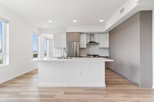A modern kitchen with a large island and stainless steel appliances.