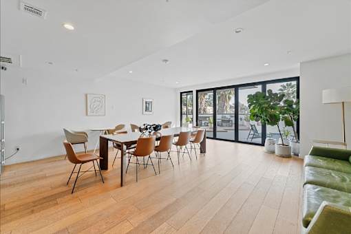 A modern dining room with a wooden table and chairs.