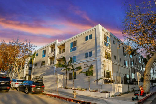 an apartment building on a city street with parked cars