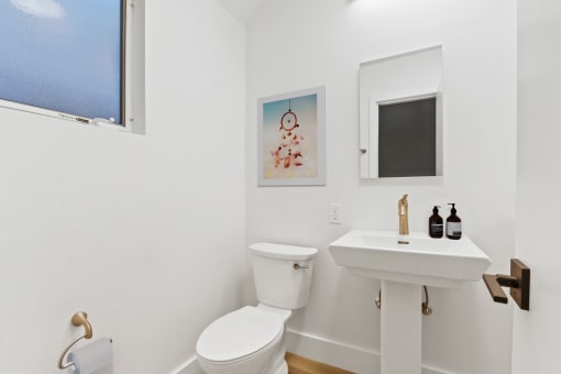 a bathroom with a toilet and a sink and a window