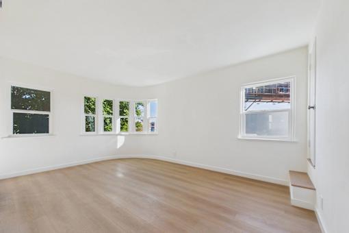 A room with a white wall and a window with a view of a snowy landscape.