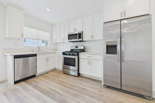 A kitchen with white cabinets and stainless steel appliances.