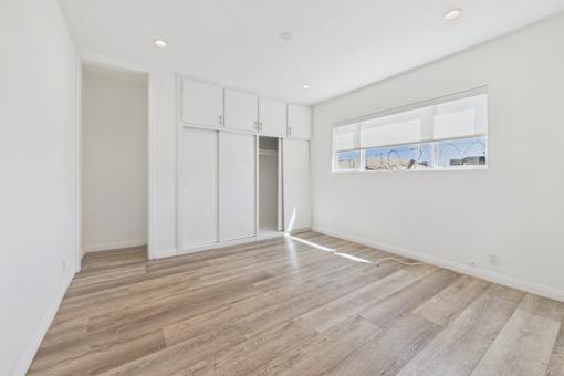 A room with a large window and wooden flooring.