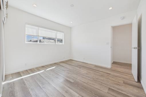 A room with a large window and wooden flooring.