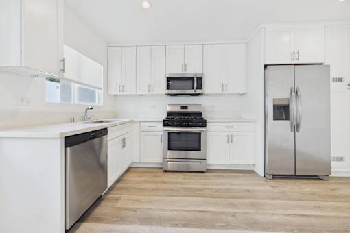 A kitchen with white cabinets and stainless steel appliances.