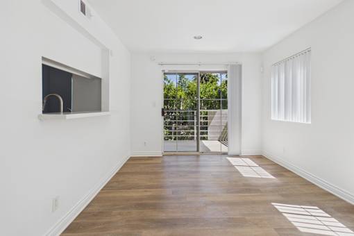 A room with a sliding glass door leading to a balcony.