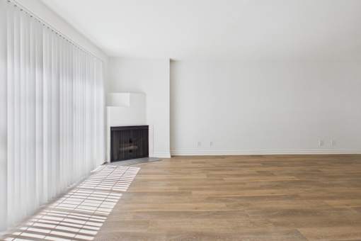 A room with a fireplace and a wooden floor.