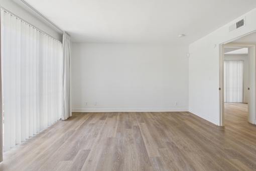 A room with wooden flooring and white walls.