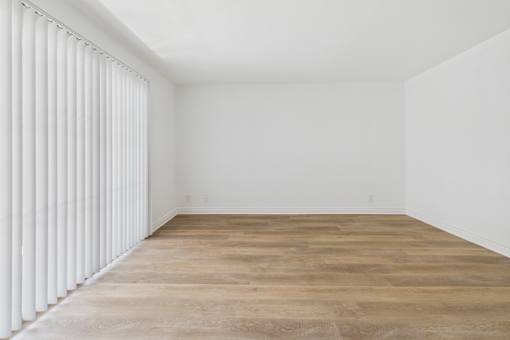 A room with wooden flooring and white walls.