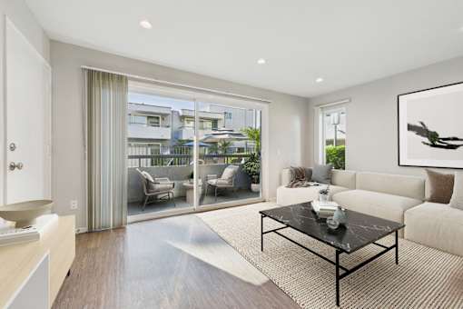 A modern living room with a glass door leading to a balcony.