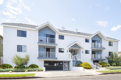 a white apartment building with a street in front of it