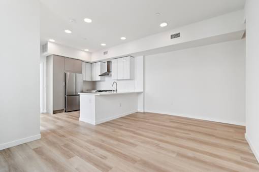 A kitchen with a refrigerator, sink, and cabinets.