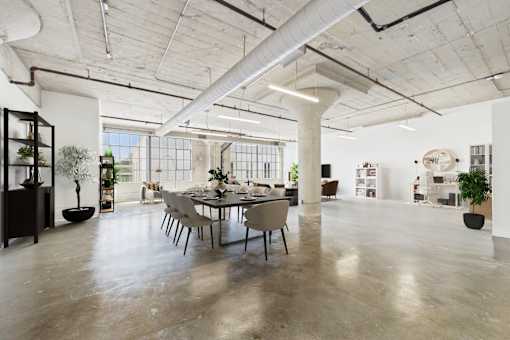 A large, open-plan office space with a dining table in the center.