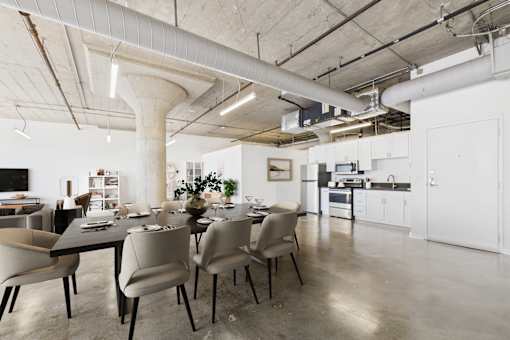 A modern dining room with a long table and chairs.