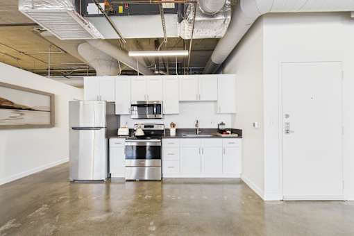 A modern kitchen with white cabinets and stainless steel appliances.