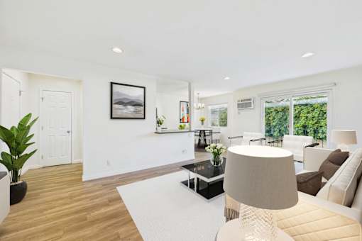 A modern living room with a glass coffee table and a large window.