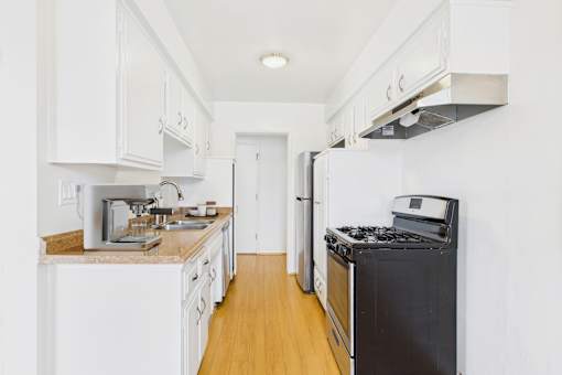 A kitchen with white cabinets and a black stove top oven.