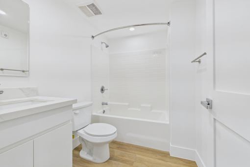 A white bathroom with a toilet, sink, and bathtub.