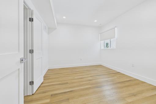 A room with a white door and a wooden floor.