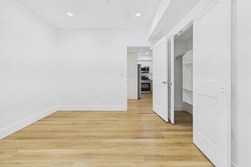 A long hallway with a white door on the right.
