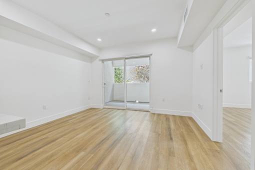 A room with wooden floors and a sliding glass door.