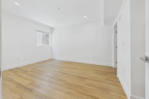 A room with wooden flooring and white walls.